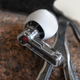 A close-up of the squeeze control on the stem of a Nothing Ear (stick) earbud.